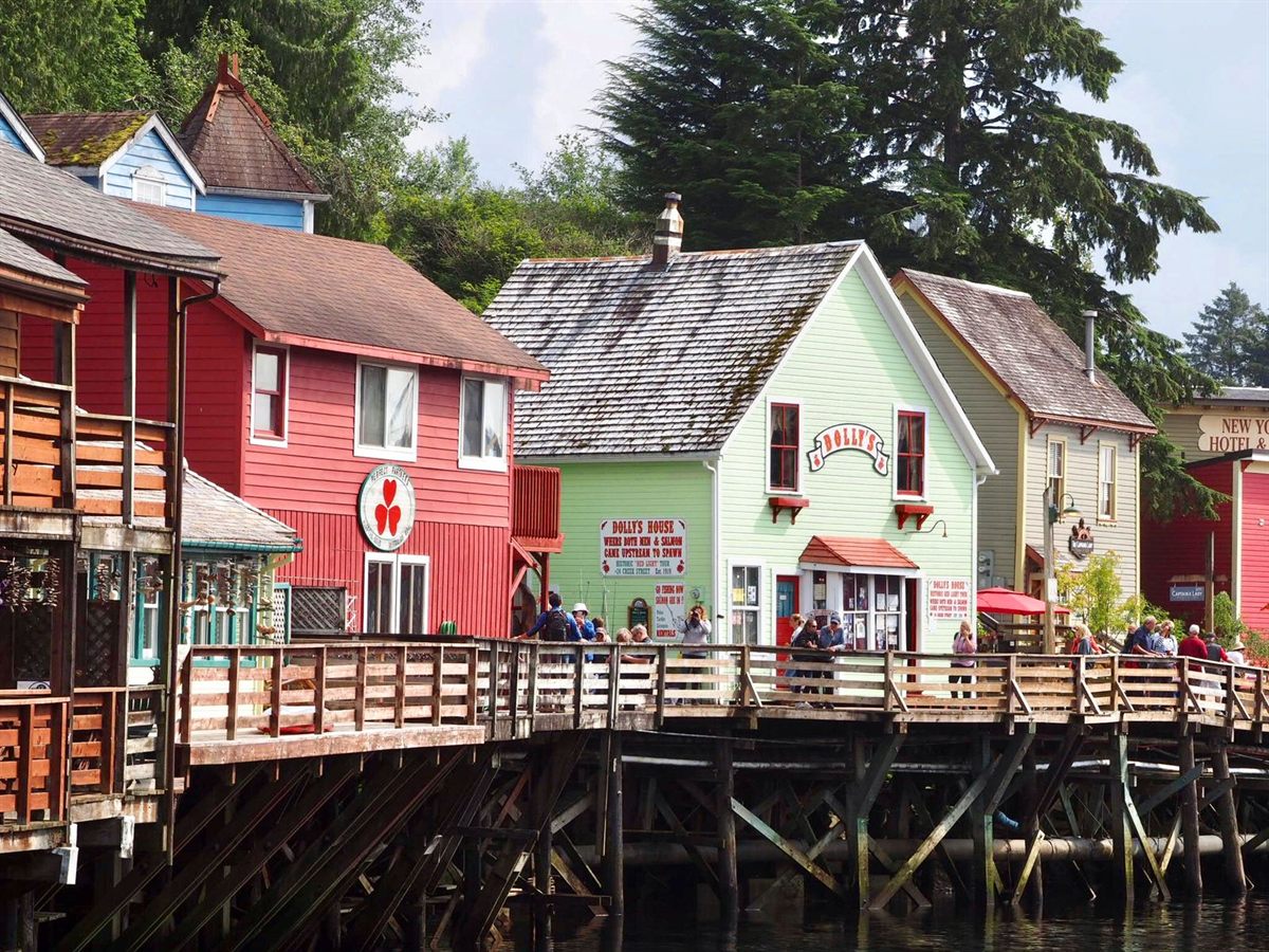 Colorful wooden buildings on a boardwalk above a creek in Ketchikan, Alaska