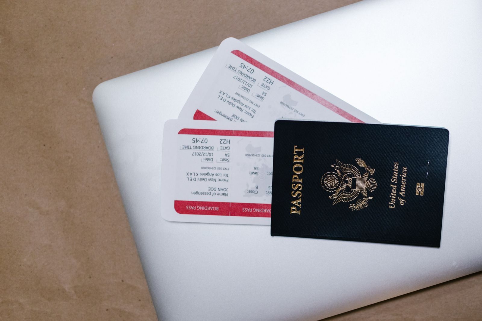A U.S. passport and two boarding passes on a laptop, the big items in a cruise vacation budget