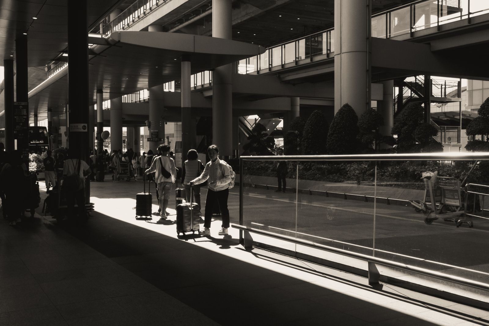 Travelers with suitcases in a bright airport terminal, arriving the day before a cruise